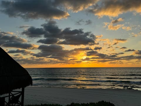 Sunrise over the Caribbean Sea from a beachfront palapa in Mexico