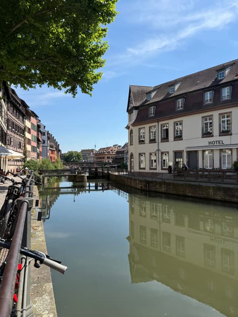 Historic buildings reflected in a calm canal in Strasbourg, France